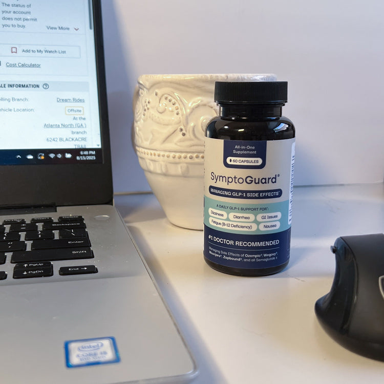 SymptoGuard supplement bottle on a desk next to a laptop