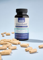 A bottle of SymptoGuard® on a table surrounded by loose supplement pills.
